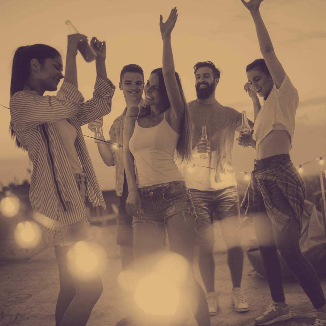 group of people partying and drinking on the beach